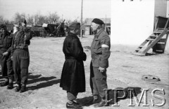 Kwiecień 1942, Jangi-Jul, Uzbekistan, ZSRR.
Służbowy na dziedzińcu rozmawia z żołnierzem w płaszczu.
Fot. Stanisław Lipiński, Instytut Polski im. Gen. Sikorskiego w Londynie [album negatywowy A-I ROSJA] - płachta 25a
