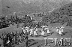 Kwiecień-maj 1942, Dżałał-Abad, Kirgistan, ZSRR.
Scena w plenerze, na niej tańczące pary artystów, na lewo orkiestra, na zboczach wzgórz siedzą żołnierze oglądający występy.
Fot. inż. Ostrowski, Instytut Polski im. Gen. Sikorskiego w Londynie [album negatywowy A-I ROSJA] - płachta 33