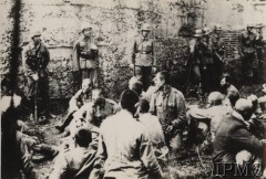 7.09.1939, Westerplatte, Polska.
Polscy jeńcy siedzą przed jednym z bunkrów na Westerplatte pilnowani przez niemieckich żołnierzy.
Fot. Foto-Sonnke, Instytut Polski i Muzeum im. gen. Sikorskiego w Londynie [szuflada nr 51]
