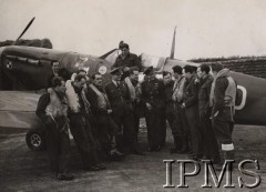 11.11.1942, Kirton-in-Lindsey, Wielka Brytania.
Lotnicy 303 Dywizjonu Myśliwskiego na tle samolotu mjr Jana Zumbacha. Stoją od lewej: ppor. Tadeusz Kołecki, por. Kobylański, ppor. Stanisław Podobiński (zasłonięty), por. Zygmunt Bieńkowski, kpt. Stefan Witorzeńć, st. sierż. Mieczysław Popek, mjr Jan Zumbach, sierż. Palach (Pałach), sierż. Józef Stasik, por. Longin Majewski, sierż. Józef Karczmarz, por. Zbigniew Zarębski, na tle kabiny samolotu por. Antoni Głowacki, na skrzydle siedzi st. sierż. Mieczysław Adamek.
Fot. NN, Instytut Polski i Muzeum im. gen. Sikorskiego w Londynie [teczka nr 26]