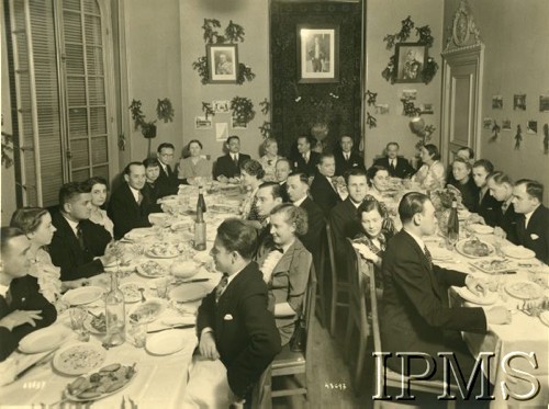 1926-1935, Polska.
Grupa osób za stołem, na ścianie wiszą zdjęcia Marszałka Józefa Piłsudskiego, prezydenta Ignacego Mościckiego i gen. Edwarda Rydza-Śmigłego.
Fot. NN, Instytut Polski i Muzeum im. gen. Sikorskiego w Londynie