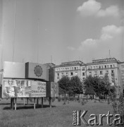 1972, Kraków, Polska.
Skwer na nowohuckim osiedlu. Na rusztowaniach wiszą plakaty z propagandowymi hasłami 