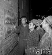 II poł. lat 70., Kraków, Polska.
Hala Kombinatu Metalurgicznego Huty im. Lenina. Hutnicy stoją przy tablicy z zapisanymi wskaźnikami wydajności pieca martenowskiego nr 8.
Fot. Stanisław Gawliński, zbiory Ośrodka KARTA