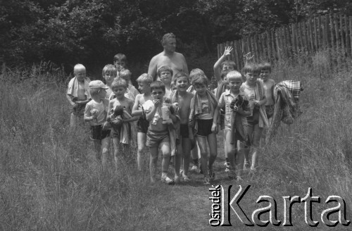 Czerwiec-lipiec 1987, Porąbka, woj. śląskie, Polska.
Kolonie dla dzieci pracowników Huty im. Lenina. Opiekun prowadzi grupę dzieci nad potok Wielka Puszcza.
Fot. Stanisław Gawliński, zbiory Ośrodka KARTA