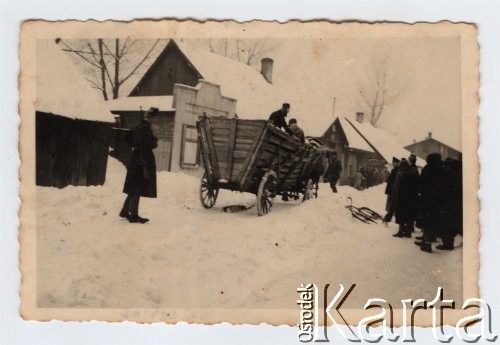 Listopad 1941 - sierpień 1943, Zawiercie, Górny Śląsk, Polska.
Żydowskie getto. Wóz z dwoma Żydami, kilkunastu Żydów zgromadzonych przed wozem. Na pierwszym planie funkcjonariusz Schutzpolizei z bronią na ramieniu.
Fot. NN, zbiory Ośrodka KARTA, przekazał Simcha Nornberg