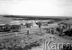 Początek XX wieku, Comodoro Rivadavia, prowincja Chubut, Argentyna.
Skład towarów przy torach kolejowych.
Fot. NN, zbiory Museo Ferroportuario w Comodoro Rivadavia, reprodukcje cyfrowe w  Bibliotece Polskiej im. Ignacego Domeyki w Buenos Aires (Biblioteca Polaca Ignacio Domeyko) i w Ośrodku KARTA w Warszawie