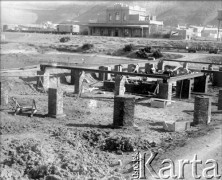 Wrzesień 1933, Comodoro Rivadavia, prowincja Chubut, Argentyna.
Budynek stacji kolejowej (w głębi). 
Fot. NN, zbiory Museo Ferroportuario w Comodoro Rivadavia, reprodukcje cyfrowe w  Bibliotece Polskiej im. Ignacego Domeyki w Buenos Aires (Biblioteca Polaca Ignacio Domeyko) i w Ośrodku KARTA w Warszawie