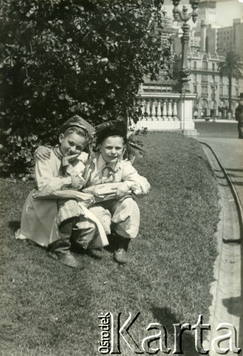 Lata 50., Buenos Aires, Argentyna.
Dwaj chłopcy  w strojach krakowiaków na głównym placu w Buenos Aires.(Plaza de Mayo).
Fot. NN, zbiory Polskiej Macierzy Szkolnej, reprodukcje cyfrowe w  Bibliotece Polskiej im. Ignacego Domeyki w Buenos Aires (Biblioteca Polaca Ignacio Domeyko) i w Ośrodku KARTA w Warszawie