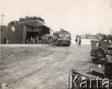 1944, Włochy.
Wyładunek sprzętu wojskowego oddziałów amerykańskich w jednym z włoskich portów. W lewym rogu zdjęcia pieczątka: 