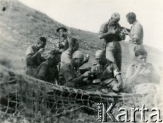 Maj 1944, rejon Monte Cassino, Włochy.
Sanitariusze i żołnierze 2 Korpusu podczas posiłku, na pierwszym planie siatka maskująca.
Fot. kpt. lekarz Zbigniew Godlewski, zbiory Instytutu Józefa Piłsudskiego w Londynie


