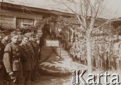 19.03.1920, brak miejsca.
Dzień imienin Naczelnika Państwa Józefa Piłsudskiego. Żołnierze zgromadzeni przed kwaterą dowództwa pułku obok białego orła ułożonego z kamieni, nad którym wiszą dwa skrzyżowane karabiny, napis 