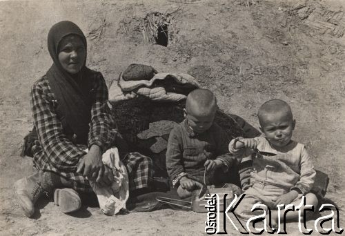 1942, Wrewskoje, Uzbekistan, ZSRR.
Obóz dla ludności cywilnej przy powstającej Armii Andersa, kobieta i dwoje dzieci, jedzących kaszę z menażki.
Fot. NN, zbiory Instytutu Józefa Piłsudskiego w Londynie