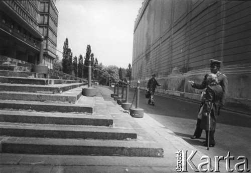 1984, Warszawa, Polska.
Ulica Nowy Świat. Na tyłach gmachu będącego siedzibą KC PZPR (obecnie mieszczącego Centrum Bankowo-Finansowe), znanego jako Dom Partii. Funkcjonariusz Milicji Obywatelskiej rozmawia z kobietą.
Fot. Kacper Mirosław Krajewski, zbiory Ośrodka KARTA