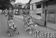 1995, Warszawa, Polska.
Młode matki na spacerze z dziećmi na ulicy Bartyckiej, obok giełdy budowlanej. W tle widoczna reklama klejów Atlas.
Fot. Kacper M. Krajewski, zbiory Ośrodka KARTA