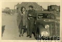 Sierpień 1945, Westerland/Sylt, Niemcy.
Polski oficer łącznikowy 174 Baterii 58 Pułku Artylerii Przeciwlotniczej wchodzącej w skład 11 Dywizji Pancernej Wielkiej Brytanii przy samochodzie w towarzystwie kobiety.
Fot. NN, zbiory Ośrodka KARTA, album Zofii i Czesława Michalskich, przekazał Adam Pyrek