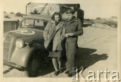 Sierpień 1945, Westerland/Sylt, Niemcy.
Polski oficer łącznikowy 174 Baterii 58 Pułku Artylerii Przeciwlotniczej, wchodzącej w skład 11 Dywizji Pancernej Wielkiej Brytanii, przy samochodzie w towarzystwie kobiety.
Fot. NN, zbiory Ośrodka KARTA, album Zofii i Czesława Michalskich, przekazał Adam Pyrek
