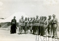 Kwiecien 1943, Jalawla, Irak.
Żołnierze Samodzielnej Brygady Strzelców Karpackich wraz z księdzem, na terenie obozu wojskowego. 4. od prawej stoi Roman Guziorski. Z tyłu napis 