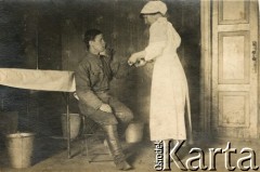 1915-1918, prawdopodobnie Ukraina.
6 Gospodarczy Czołowy Oddział Sanitarny (przemianowany później na Korpusową Kolumnę Sanitarną) imperialnej armii rosyjskiej. Oddział przeszedł w 1917/1918 roku do II Korpusu Polskiego na Wschodzie. Sanitariuszka opatruje żołnierza.
Fot. NN, zbiory Ośrodka KARTA, przekazała Wanda Ustaszewska-Szamborska