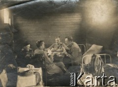 1915-1918, prawdopodobnie Ukraina.
Żołnierze 6 Gospodarczego Czołowego Oddziału Sanitarnego (przemianowanego później na Korpusową Kolumnę Sanitarną) imperialnej armii rosyjskiej grający w karty. Oddział przeszedł w 1917/1918 roku do II Korpusu Polskiego na Wschodzie.
Fot. NN, zbiory Ośrodka KARTA, przekazała Wanda Ustaszewska-Szamborska
