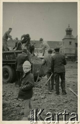 Po 1945, Polska.
Grupa mężczyzn zrzuca łopatami ziemię z wozu. Na pierwszym planie stoi dziecko. 
Fot. NN, kolekcja Witolda Staszkiewicza, zbiory Ośrodka KARTA 

