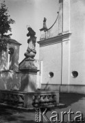 Lata 30., Polska.
Figura przez niezidentyfikowanym kościołem.
Fot. NN, kolekcja Witolda Lis-Olszewskiego, zbiory Ośrodka KARTA