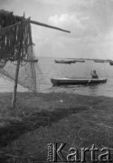 Lata 30, wybrzeże Bałtyku, Polska.
Kobieta w kajaku, zacumowane łodzie.
Fot. NN, kolekcja Witolda Lis-Olszewskiego, zbiory Ośrodka KARTA