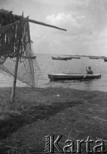 Lata 30, wybrzeże Bałtyku, Polska.
Kobieta w kajaku, zacumowane łodzie.
Fot. NN, kolekcja Witolda Lis-Olszewskiego, zbiory Ośrodka KARTA