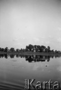 1928-1936, Polesie, Polska.
Zabudowania na brzegu rzeki. Zdjęcie wykonane podczas spływu kajakowego.
Fot. NN, kolekcja Witolda Lis-Olszewskiego, zbiory Ośrodka KARTA