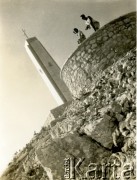 2.07.1945, Monte Cassino, wzgórze 593, Włochy.
Dwaj żołnierze polscy na tle pomnika - obelisku upamietniającego poległych żołnierzy 3 Dywizji Strzelców Karpackich na polskim cmentarzu wojennym. Na zwieńczeniu pomnika umieszczono krzyż, a poniżej spiżowe orły i oznaki dywizyjne oraz napis w czterech językach skierowany w cztery strony świata, by głosić ich ponadczasowe znaczenie: