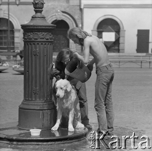 1973, Warszawa, Polska.
Para polewająca psa wodą z pompy na Rynku Starego Miasta.
Fot. Lubomir T. Winnik, zbiory Ośrodka KARTA