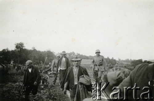 1939-1945, brak miejsca.
Mężczyźni pracujący pod nadzorem uzbrojonych Niemców.
Fot. NN, album nieznanego żołnierza Wehrmachtu, kolekcja Tomasza Kopańskiego, zbiory Ośrodka KARTA