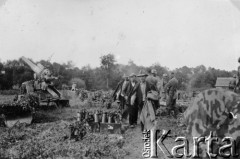 1939-1945, brak miejsca.
Mężczyźni pracujący pod nadzorem uzbrojonych Niemców. W tle niemiecka haubica 149 mm na pozycji ogniowej.
Fot. NN, album nieznanego żołnierza Wehrmachtu, kolekcja Tomasza Kopańskiego, zbiory Ośrodka KARTA