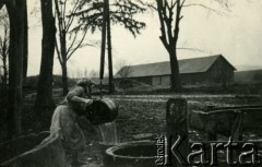 1939-1945, prawdopodobnie Jasło.
Kobieta przy studni.
Fot. NN, album nieznanego żołnierza Wehrmachtu, kolekcja Tomasza Kopańskiego, zbiory Ośrodka KARTA