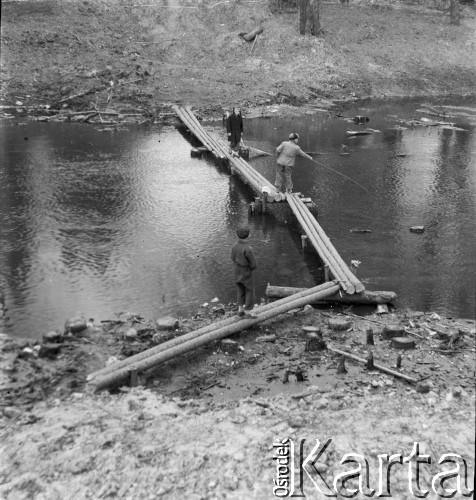 1-2.05.1959, Białowieża, woj. białostockie, Polska.
Dziennikarze w Białowieskim Parku Narodowym. Na zdjęciu stoją na tymczasowej kładce na rzece Narewka. Zdjęcie wykonane podczas wycieczki prasowej do Białowieskiego Parku Narodowego.
Fot. Jerzy Konrad Maciejewski, zbiory Ośrodka KARTA.