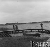 1960, Biskupin, Polska.
Turyści na kładce na Jeziorze Biskupińskim w drodze do osady obronnej kultury łużyckiej. Biskupin został odkryty pod wodami Jeziora Biskupińskiego przez archeologów w 1934 r.  
Fot. Jerzy Konrad Maciejewski, zbiory Ośrodka KARTA.
