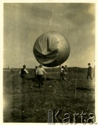 1960, Biskupin, Polska. 
Wycieczka turystyczna do osady Biskupin. Turyści ściągają balon, który unosił się nad półwyspem Jeziora Biskupińskiego.
Fot. Jerzy Konrad Maciejewski, zbiory Ośrodka KARTA.