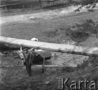 Lata 50., Bieszczady, Polska.
Prowizoryczna kładka przerzucona nad rozkopaną drogą. Przy kładce stoi chłopczyk.
Fot. Jerzy Konrad Maciejewski, zbiory Ośrodka KARTA.