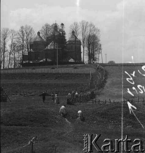 1951-1952, Bystre, Bieszczady, Polska.
Turyści zmierzają do cerkwi greckokatolickiej pw. św. Michała Archanioła. Budynek cerkwi powstał w latach 1901-1902. Greckokatolicka cerkiew była filią w Michniowcu. Została opuszczona w roku 1951, kiedy tereny te wróciły do Polski w ramach wymiany z ZSRR. Przez krótki czas mieszkańcy użytkowali ją jako kościół rzymskokatolicki. Nie zaakceptowały tego ówczesne władze i obiekt został zamknięty.
 Fot. Jerzy Konrad Maciejewski, zbiory Ośrodka KARTA.