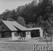 Lata 50., Bieszczady Polska.
Gospodarstwo wiejskie u podnóży gór. Widoczny drewniany dom z charakterystycznym spadzistym dachem, zabudowania gospodarskie i studnia.
Fot. Jerzy Konrad Maciejewski, zbiory Ośrodka KARTA.
