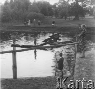 Ok. 1958, prawdopodobnie Borki k. Radzynia Podlaskiego, woj. lubelskie, Polska.
Dzieci i kobiety nad brzegiem zalewu rzeki Bystrzycy. 
Fot. Jerzy Konrad Maciejewski, zbiory Ośrodka KARTA.