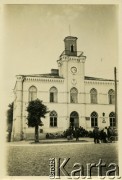 1938, Ciechanów, woj. warszawskie, Polska.
XIX-wieczny ratusz w stylu neogotyckim. Przed budynkiem siedzą bezrobotni mieszkańcy.
Fot. Jerzy Konrad Maciejewski, zbiory Ośrodka KARTA
