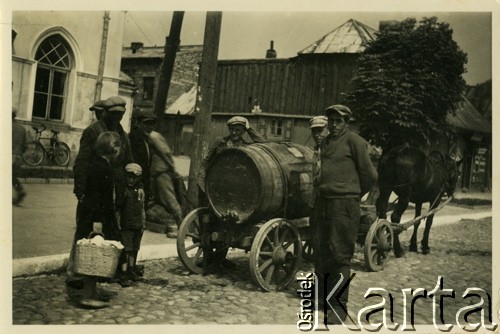 1938, Ciechanów, woj. warszawskie, Polska.
Woziwoda rozwozi wodę dla mieszkańców. Na zdjęciu ludzie otaczają wóz z beczką ciągniętą przez konia. 
Fot. Jerzy Konrad Maciejewski, zbiory Ośrodka KARTA