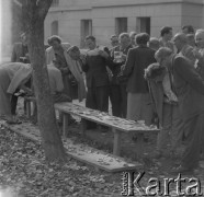 Czerwiec 1948, Cieplice Śląskie-Zdrój, woj. wrocławskie, Polska. 
Grupa ludzi ogląda prawdopodobnie fotografie rozłożone na drewnianej ławce.
Fot. Jerzy Konrad Maciejewski, zbiory Ośrodka KARTA