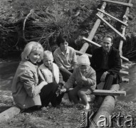 Marzec 1967, Duszniki-Zdrój, woj. wrocławskie, Polska.
Grupa turystów siedzi na drewnianej przeprawie nad rzeką.
Fot. Jerzy Konrad Maciejewski, zbiory Ośrodka KARTA