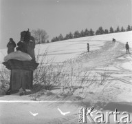 Lata 60., Duszniki-Zdrój, woj. wrocławskie, Polska.
Dzieci zjeżdżają na nartach. Na pierwszym planie widoczna przydrożna kaplica.
Fot. Jerzy Konrad Maciejewski, zbiory Ośrodka KARTA