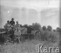 Lipiec 1951, Frombork, woj. olsztyńskie, Polska.
Turyści siedzą na spalonym niemieckim czołgu stojącym na łące. 1. z prawej siedzi Jerzy Konrad Maciejewski.
Fot. Jerzy Konrad Maciejewski, zbiory Ośrodka KARTA