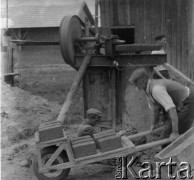 Lata 50., Gawłuszowice, woj. rzeszowskie, Polska. 
Mężczyźni wyrabiają pustki. Jeden z nich na taczce wiezie gotowy materiał do budowy domu.
Fot. Jerzy Konrad Maciejewski, zbiory Ośrodka KARTA