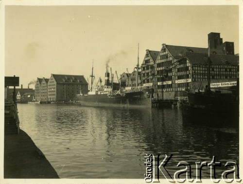 Przed 1939, Wolne Miasto Gdańsk. 
Stare Miasto nad Motławą. Widoczne niemieckie napisy zawieszone na kamienicach. Po rzece płynie statek pasażerski. 
Fot. Jerzy Konrad Maciejewski, zbiory Ośrodka KARTA