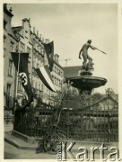 Sierpień 1939, Wolne Miasto Gdańsk. 
Fontanna Neptuna na Długim Targu, przed wejściem do Dworu Artusa. Na kamienicach wiszą flagi III Rzeszy Niemieckiej ze swastyką.
Fot. Jerzy Konrad Maciejewski, zbiory Ośrodka KARTA