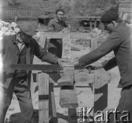 Lata 60. lub 70., Górecko Kościelne, woj. lubelskie, Polska.
Mężczyźni piłują drzewo potrzebne przy budowie kamiennej zapory wodnej na rzece Szum.
Fot. Jerzy Konrad Maciejewski, zbiory Ośrodka KARTA